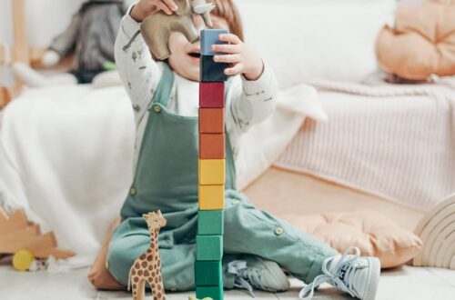 a young child engaged in creative play with colorful wooden blocks indoors